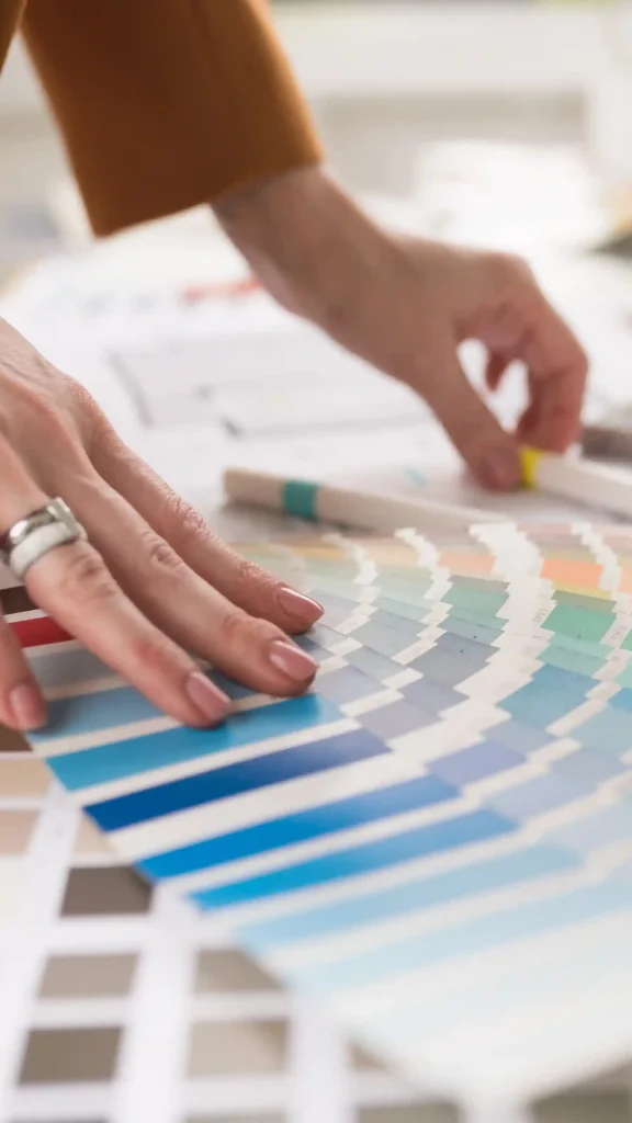 Focus su mani addetto alle vendite in un negozio di arredamento mentre seleziona campioni di colore