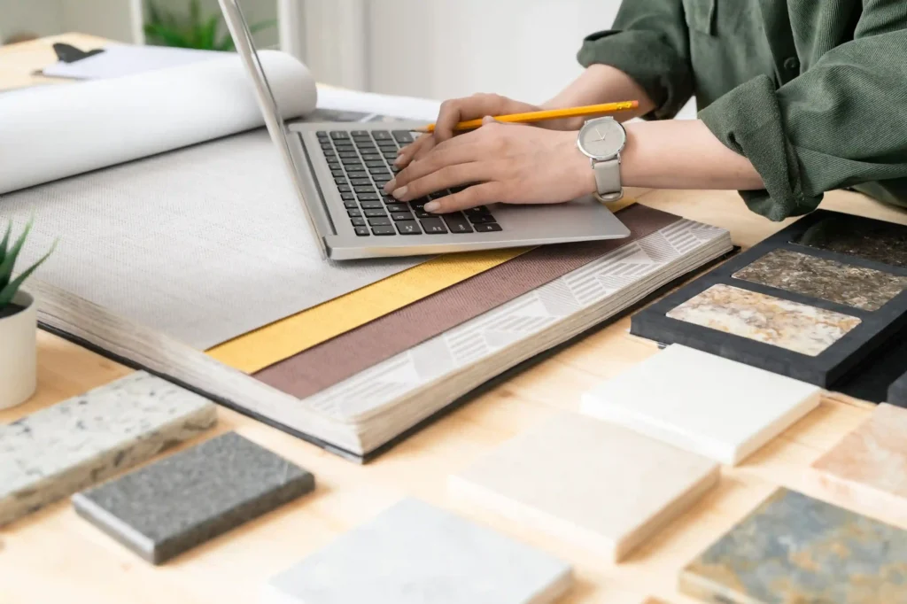Consulente alle vendite al pc mentre lavora alla selezione di materiali per la progettazione di una casa