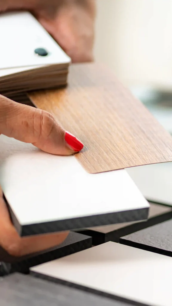Focus su mani addetto alle vendite in un negozio di arredamento mentre seleziona campioni di materiali