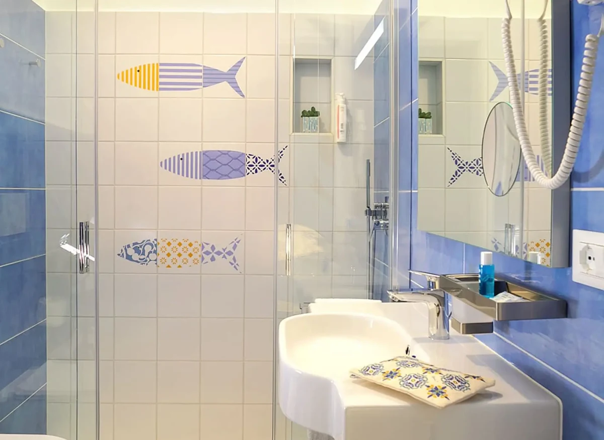 Bagno hotel sul mare con rivestimenti raffiguranti pesci