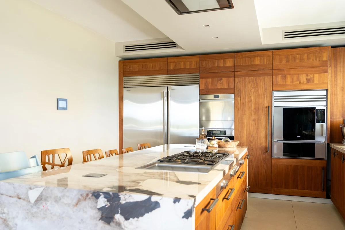 Cucina moderna con ante in legno chiaro e piano in marmo bianco
