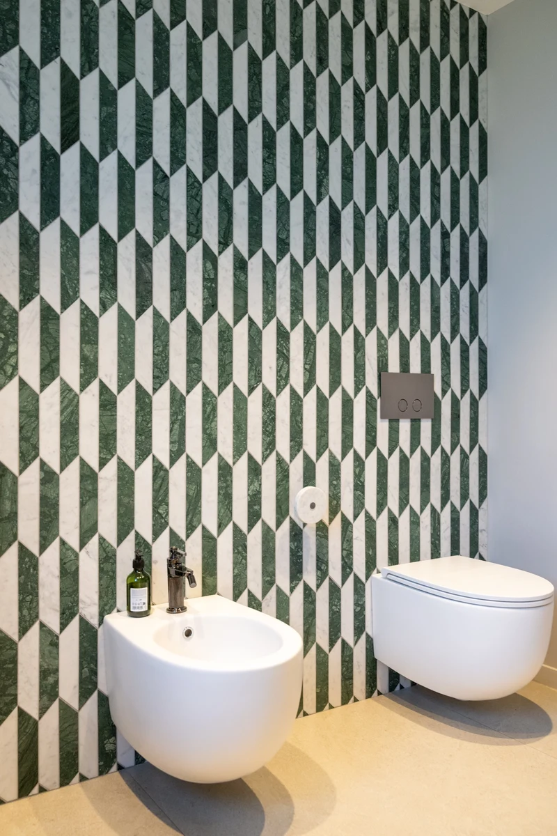 Sanitari sospesi, con parete con rivestimenti con disegni geometrici e parquet