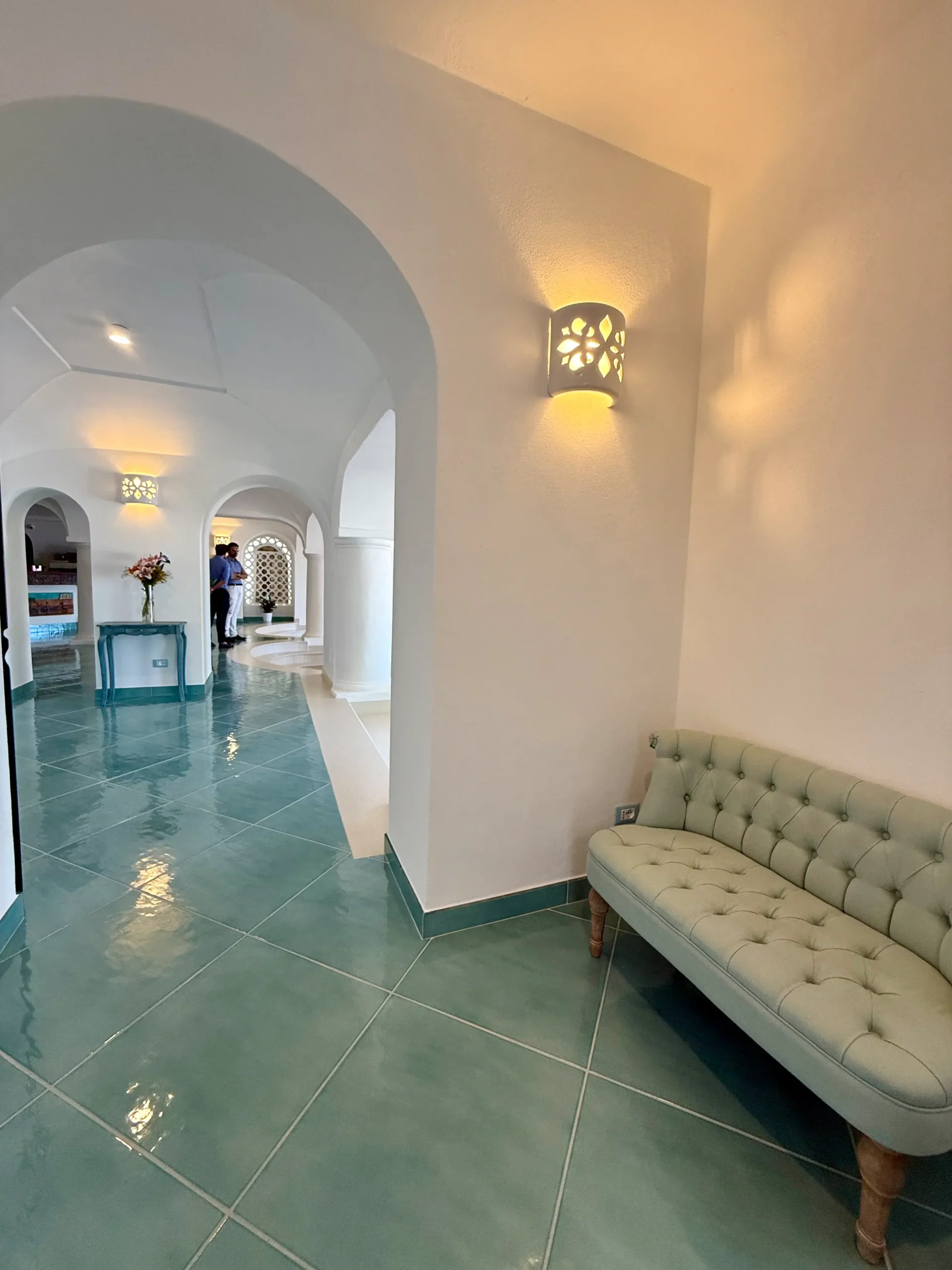 Zona hall di un hotel con pavimento con piastrelle azzurre