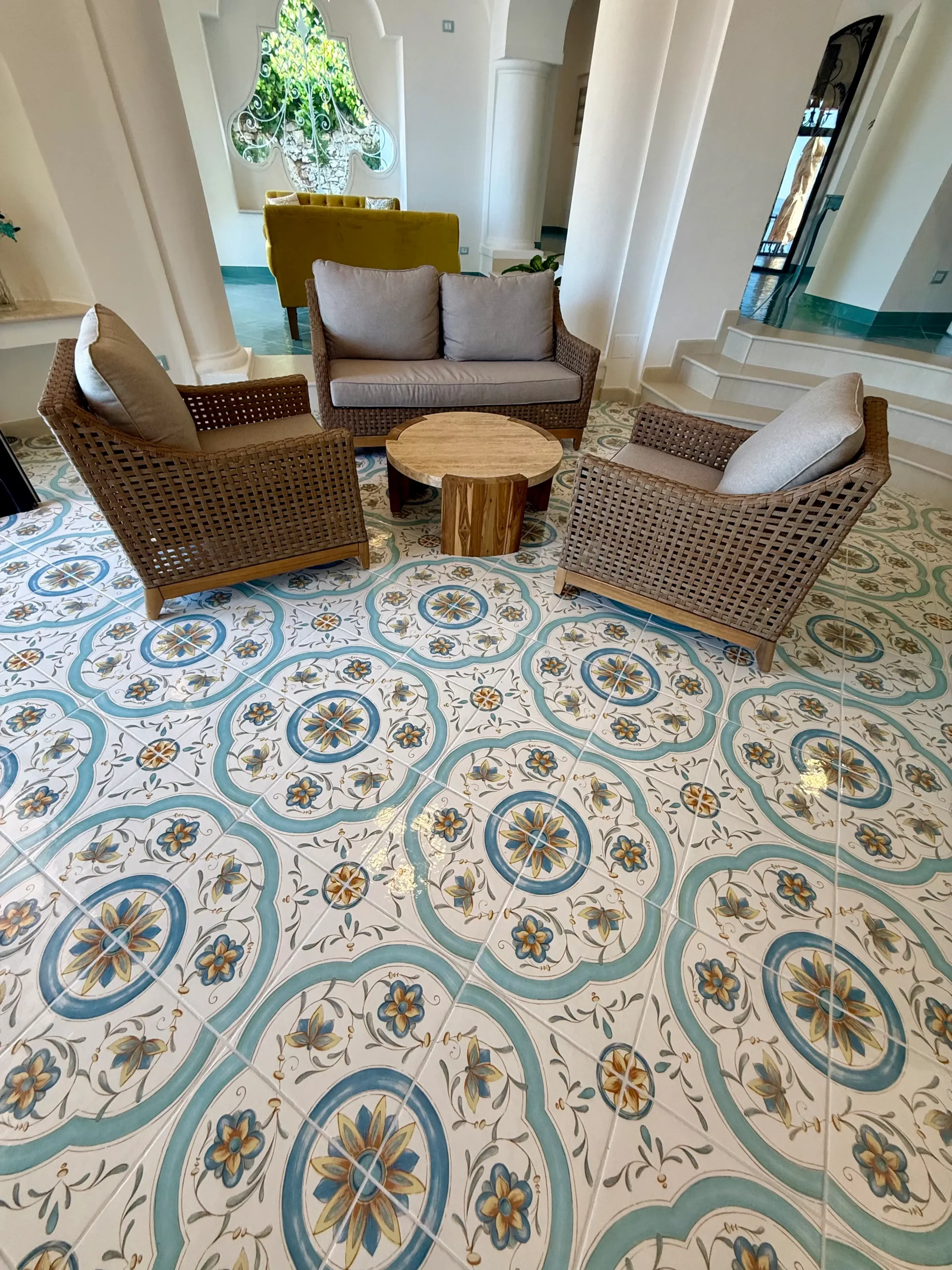 Hall con pavimento decorato con maioliche e poltroncine