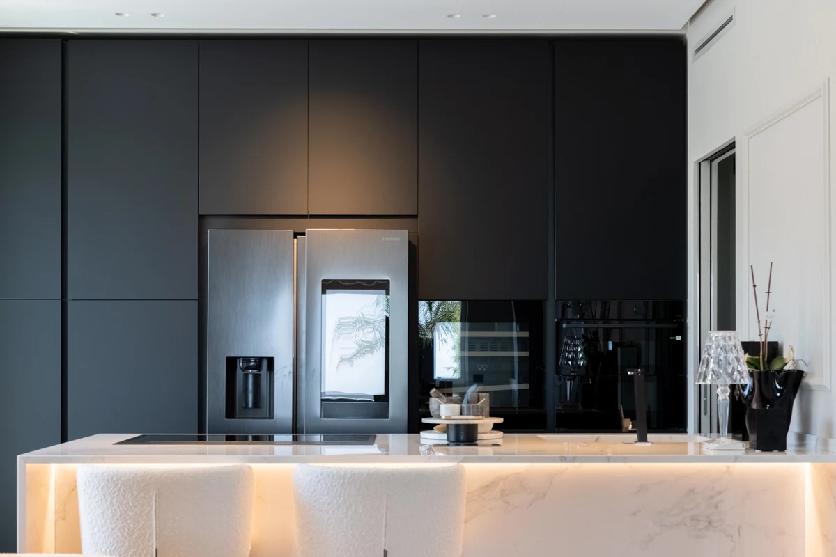 Focus cucina con piano bianco in marmo e sullo sfondo ante scure