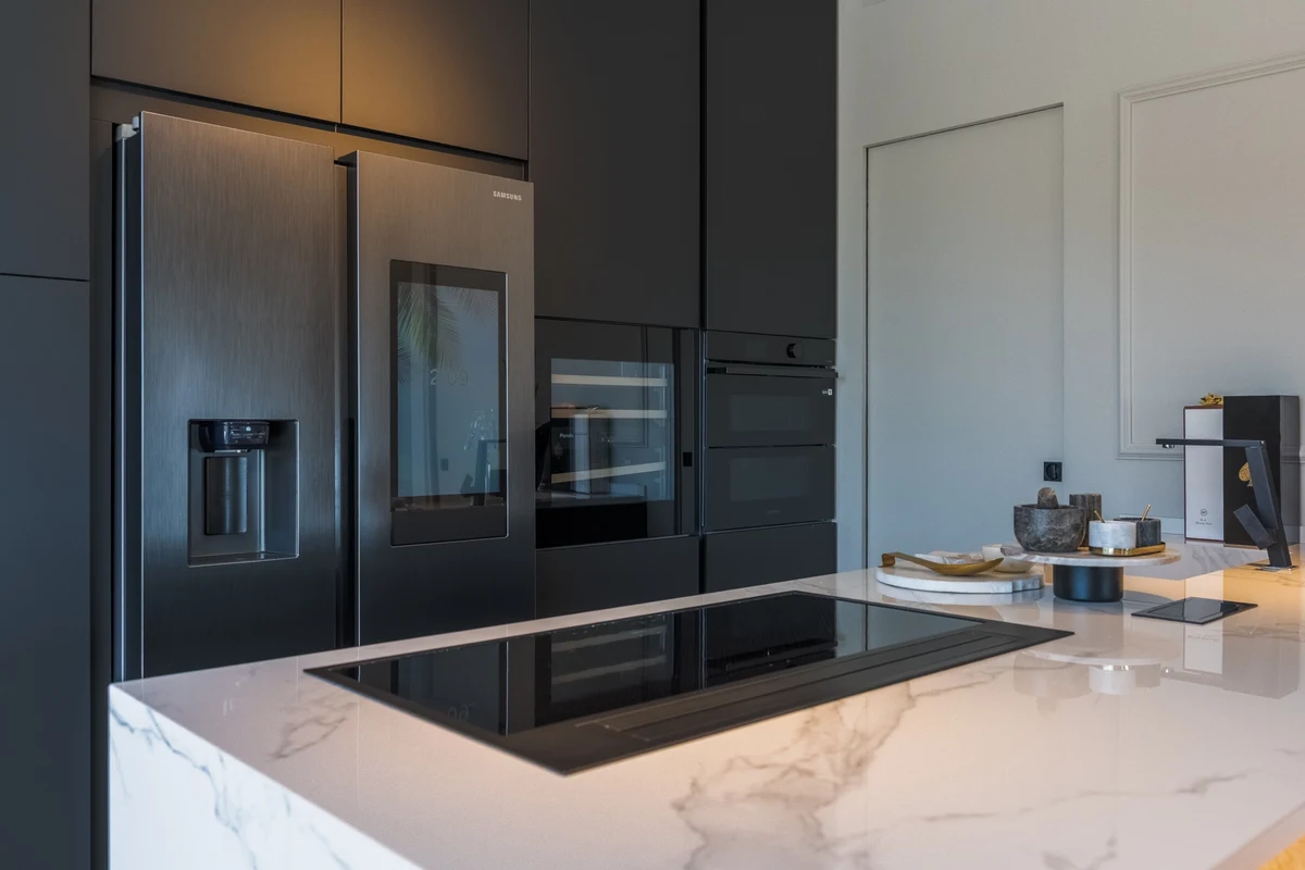 Focus cucina moderna con piano in marmo e piano cottura a induzione e ante cucina scure