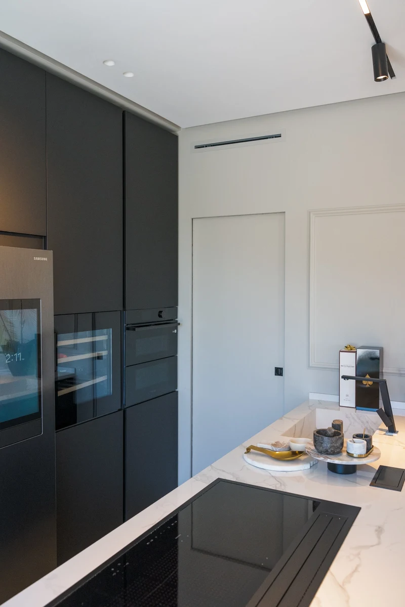 Cucina moderna con piano in marmo bianco e piano cottura a induzione