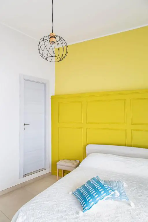 Camera da letto con boiserie gialla