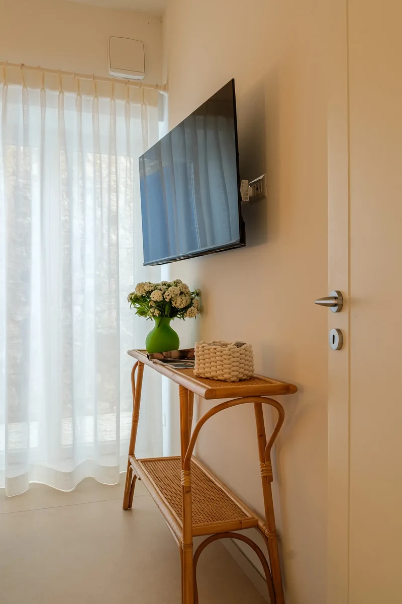 Zona camera con parete tv e consolle in legno