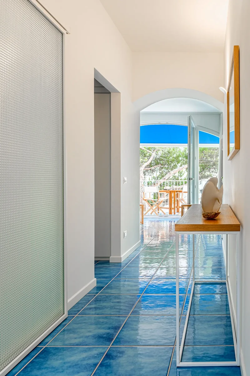 Corridoio casa al mare con piastrelle azzurre di ceramiche coem e consolle