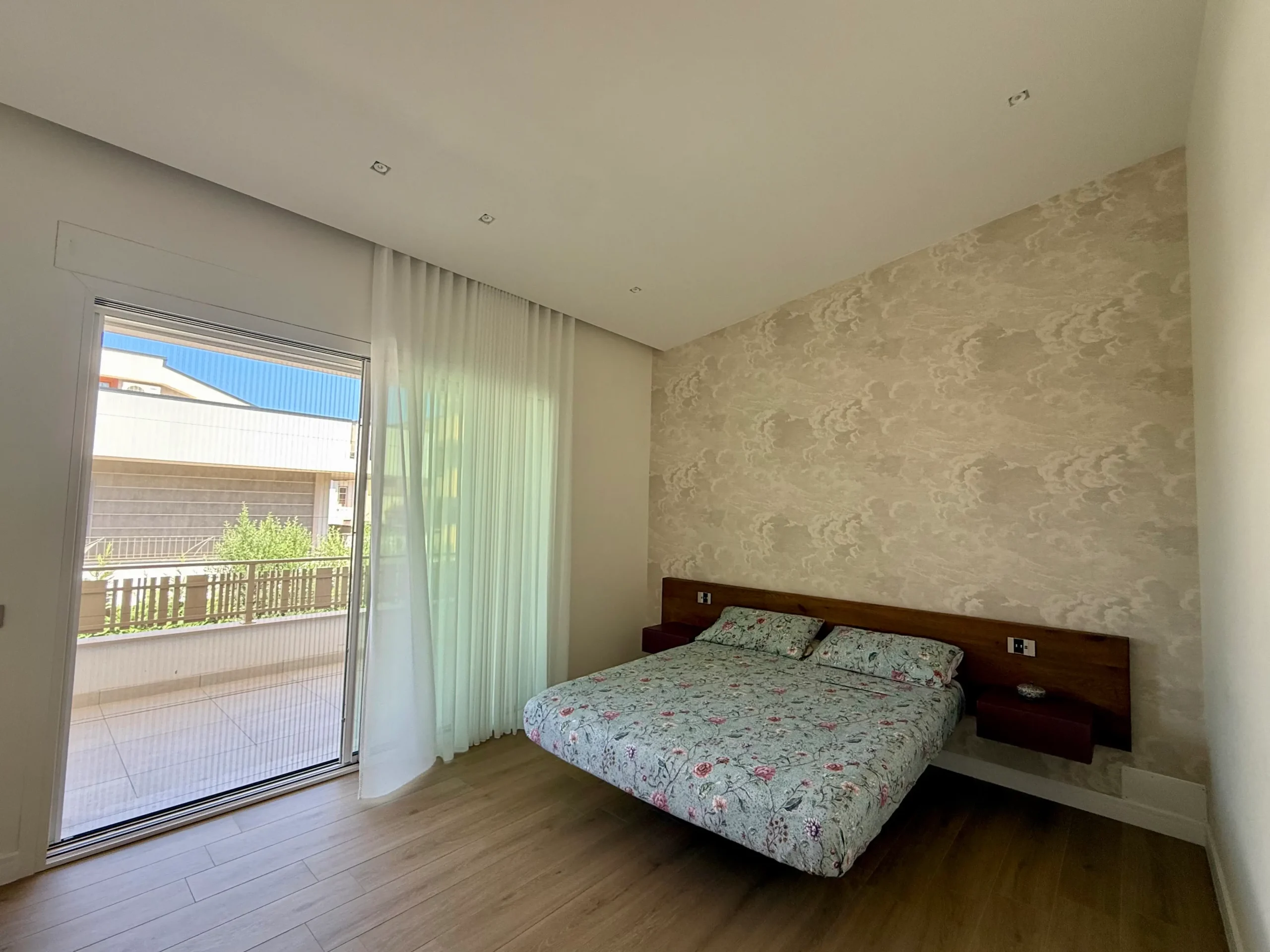Camera da letto con letto sospeso, parquet e parete con carta da parati